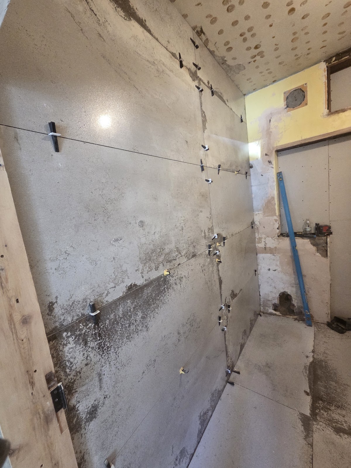 Large-format wall tiles being fitted with a levelling system